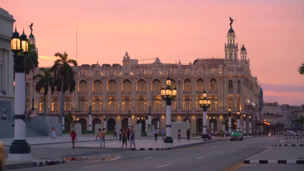 HAVANA, CUBA - 13 de maio de 2018 - Vista panorâmica de rua do Grande Teatro de Havana ao pôr-do-sol com carros antigos e pessoas em 4k — Vídeo de Stock