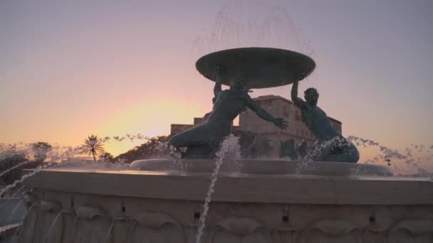VALLETTA, MALTA - 12 de noviembre de 2018 - La Fuente de Tritón en la Plaza de la Puerta de la Ciudad con manantiales de agua al atardecer en 4k — Vídeos de Stock