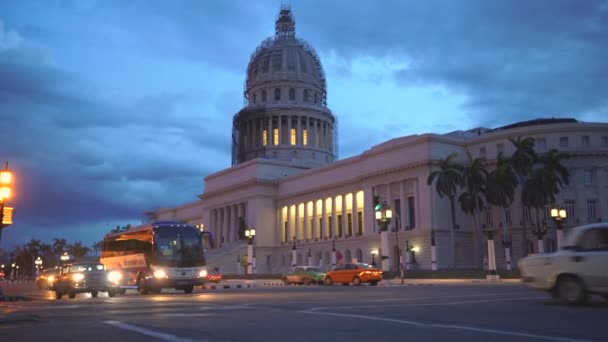 Havana, Kuba-13. května 2018-El Capitolio při západu slunce se starožitamerickými auty a lidmi v ulicích 4 k — Stock video