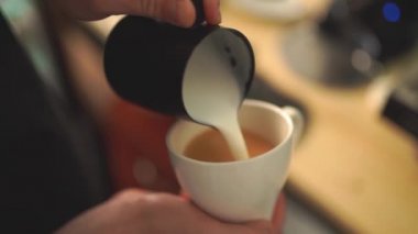 Kahvenin üzerine süt döken baristanın ağır çekimde mükemmel bir kapuçino ya da latte yaratması.
