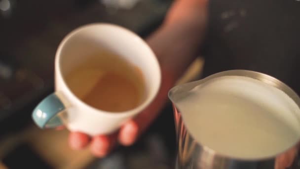 Movimento lento de barista derramando leite sobre café criando um cappuccino perfeito ou latte — Vídeo de Stock