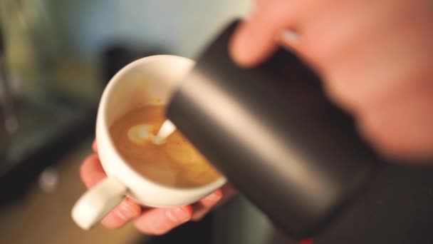 Lassú mozgás a barista öntött tejet a kávé létre egy tökéletes cappuccino vagy latte