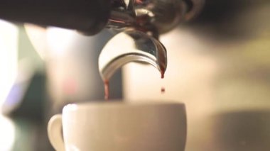 Kahve makinesi ağır çekimde sıcak espresso kahvesi dolduruyor.