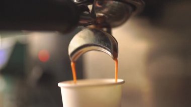 Kahve makinesi ağır çekimde sıcak espresso kahvesi dolduruyor.