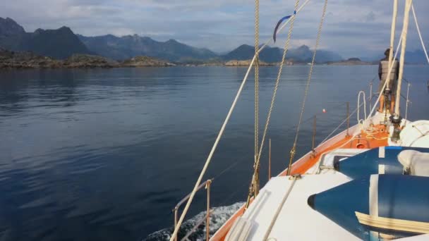 En yacht i en vattenförekomst i Norge med berg i bakgrunden — Stockvideo