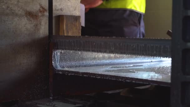 SAWING MACHINE, La scie à ruban pour la coupe industrielle de la tige de métal et l'utilisation du liquide de refroidissement dans la scène bleu clair.. — Video