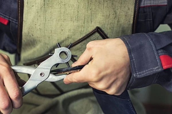 Tabakhanede çalışıyorum. Perçini ürüne takıyorum.