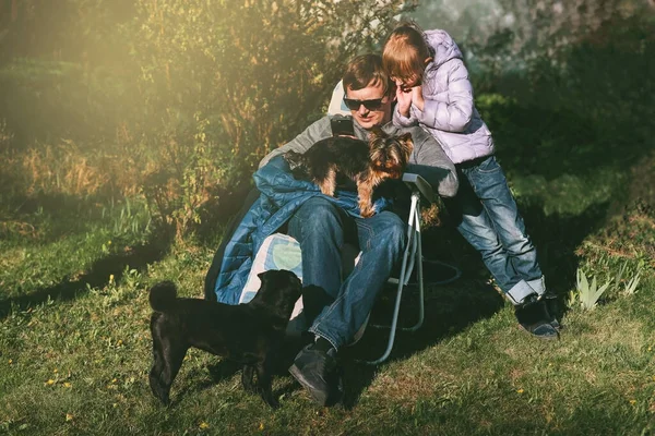 Baba ve kızı doğada birlikte akıllı telefona bakarlar.