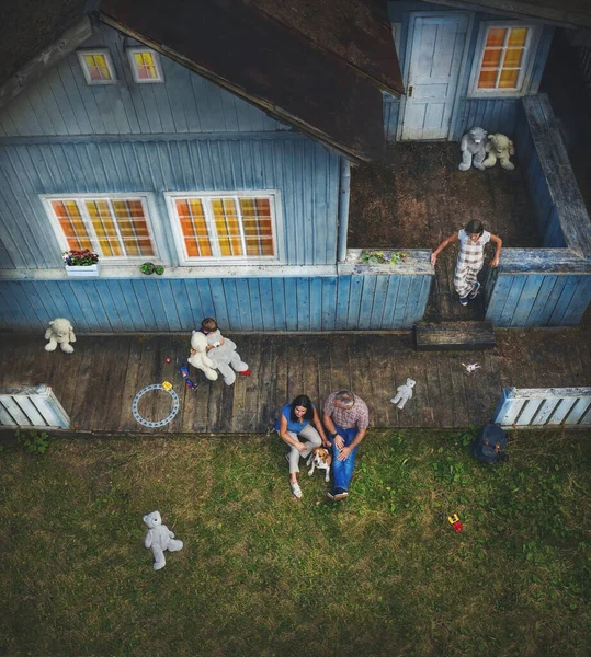 Bir aile ahşap evlerinin verandasında oturur. — Stok fotoğraf