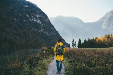Kız arkasını döner ve dağlara bakar.