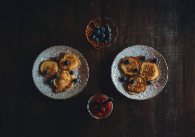 Tahta bir masada krep olan iki beyaz tabak.