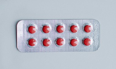 Beyaz arka plandaki pakette renkli yuvarlak haplar.