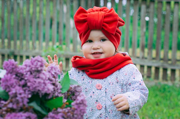 Маленькая Девочка Красной Шляпе Луком Дворе Рядом Фиолетовым Лиловым — стоковое фото