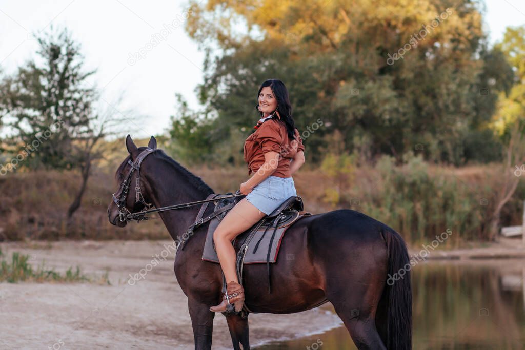 girl in a cowboy image with a horse on the lawn in autumn 