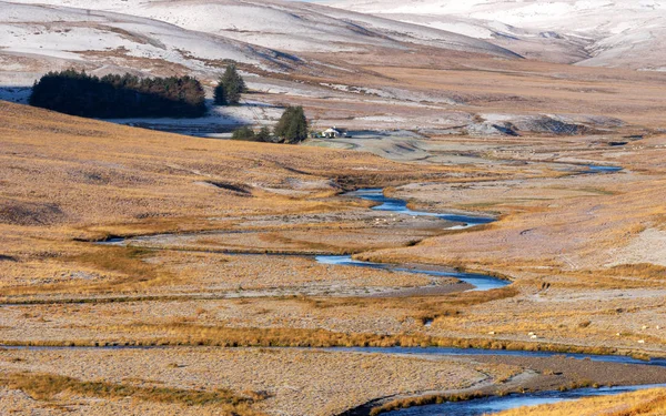 Pont Ar Elan, vale Elan, vales. Cena nevada do rio Afon elan atravessando a paisagem montanhosa com a construção de fazendas à distância — Fotografia de Stock