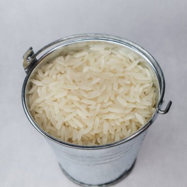 Beyaz uzun taneli pirinç bir minyatür metal kova