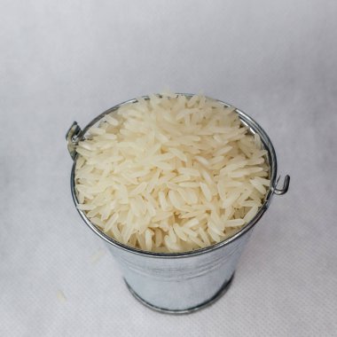 Beyaz uzun taneli pirinç bir minyatür metal kova