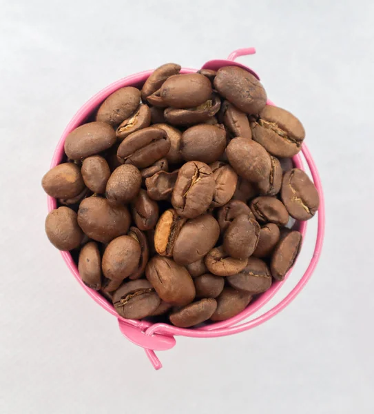 Haufen Kaffeebohnen Rosa Eimer Auf Weißem Hintergrund — Stockfoto