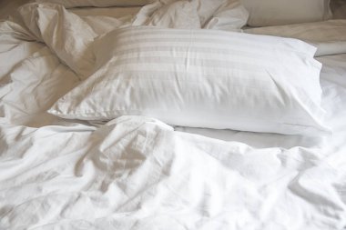 Battaniye, yatak levha ve gölge ile yatağa beyaz yastık.