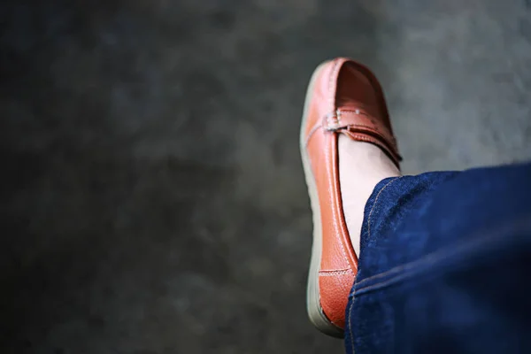 女式鞋穿橙色鞋和牛仔裤 复制空间和深色背景 — 图库照片