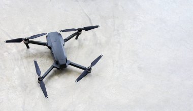 Beton zemin ve kopyalama alanı üzerinde siyah drone.