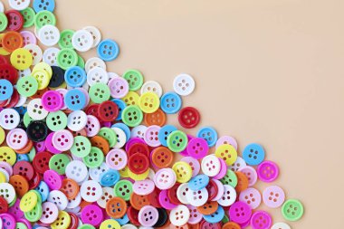 Şeftali rengi arkaplanda plastik düğme ve kopyalama alanı