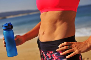 Çalışmadan sonra sahilde su içen kadın.