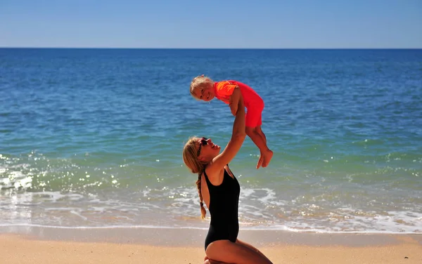 Maman avec sa fille sur la plage de sable — Photo