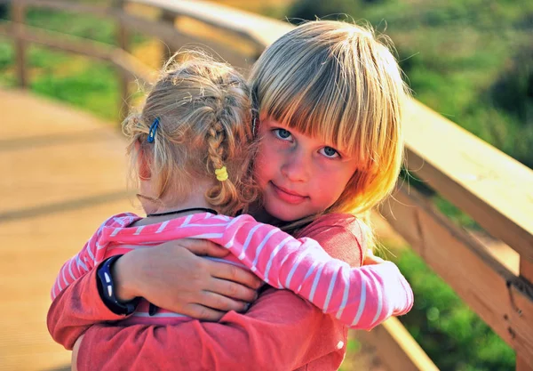 Piccolo ragazzo biondo che abbraccia sua sorella all'aperto — Foto Stock