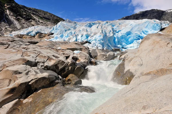 Nigardsbreen and rocky stream in mountains — Stock Photo, Image