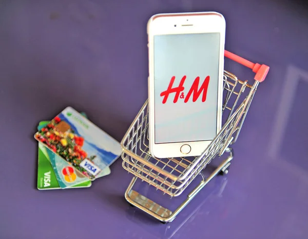 购物车中带有 H&M 徽标的智能手机 — 图库照片