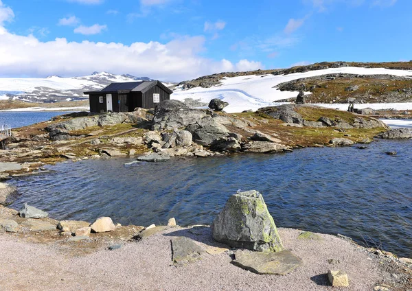 Paysage nordique enneigé avec maison noire sur le lac — Photo