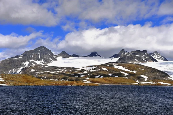Horské vrcholy nad jezerní vodou, Norsko Stock Fotografie