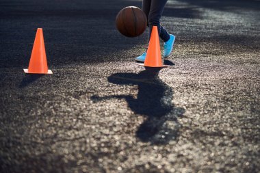 Spor salonunda ya da açık havada antrenman için koni şeklinde spor malzemeleri. Koyu bir yüzeyde turuncu koniler. Futbol antrenmanı. Çocuklar ve yetişkinler için spor eğitimi ve dersler