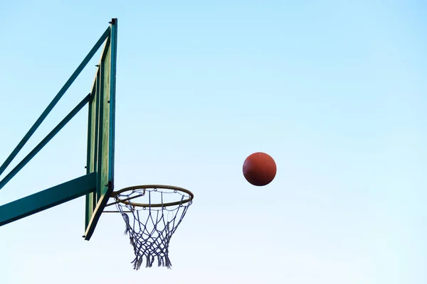 篮球篮筐和盾.球直奔篮筐.用一个球在新鲜的空气中运动。篮球实践. — 图库照片