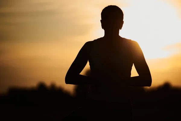 silhouette of a woman doing yoga in the fresh air. The concept of a healthy lifestyle. Outdoor recreation. Meditation and yoga classes