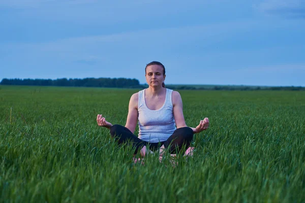 woman doing yoga in the fresh air. The concept of a healthy lifestyle. Outdoor recreation. Meditation and yoga classes
