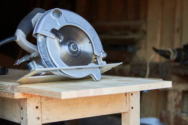 Un operaio che utilizza una sega circolare lavora con il legno in un laboratorio di falegnameria — Foto Stock