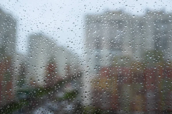 Raindrops on the glass. A modern residential complex is visible in the focus — Stock Photo, Image