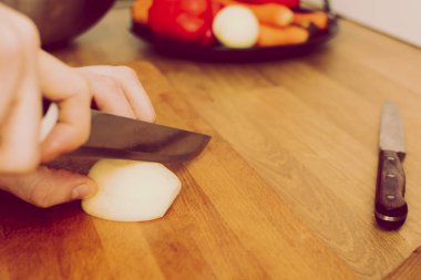 Tahta tahtada sebze doğrayan bir adam. Soğan, havuç, kırmızı biber. retro vintage tarzı