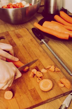 Tahta tahtada sebze doğrayan bir adam. Soğan, havuç, kırmızı biber. retro vintage tarzı