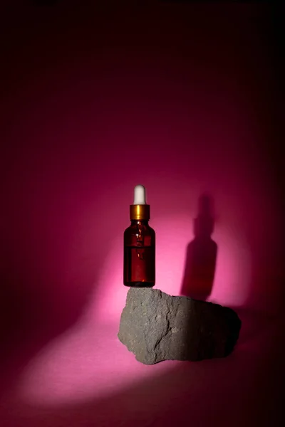 Ένα Καλλυντικό Μπουκάλι Πιπέτα Ισορροπεί Μια Γκρι Πέτρα Ροζ Φόντο — Φωτογραφία Αρχείου