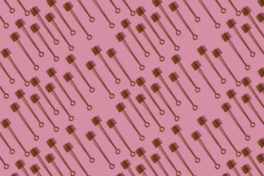 Koyu gölgeli pembe bir arka planda bal için altın kaşıktan desen