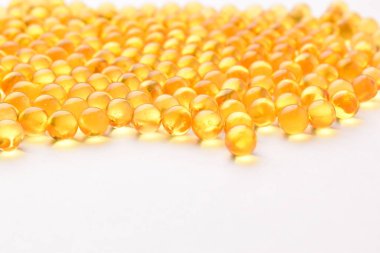 Beyaz arka planda balık yağı hapları.