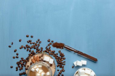 Bir fincan çay ya da şekerli kahve. Şeker ve Baharatlar. Bir avuç dolusu kahve. Noel süsleri. mavi ya da su arkaplanı