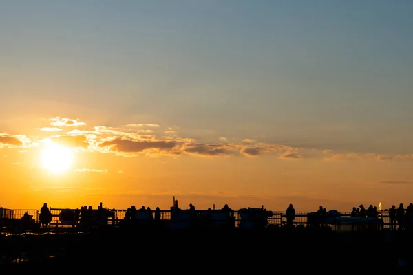 Silhuetas Jovens Sentados Telhado São Petersburgo Fundo Pôr Sol Laranja — Fotografia de Stock