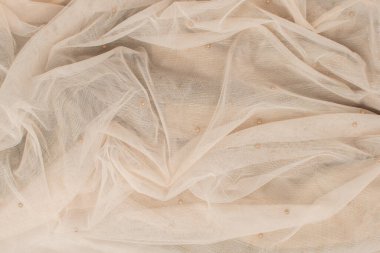 Bej rengi buruşuk tül ve küçük boncuklar. Soyut arkaplan, boş şablon