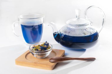 Çaydanlık ve bardak mavi çay ahşap kaşık ve kase dolusu mavi Thai çayı.