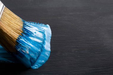 Mavi renkte boya fırçası. Yakın plan. Karanlık arka plan. Boşluğu kopyala
