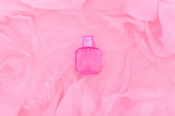 Διαφανές Γυάλινο Μπουκάλι Καλλυντικών Αρωμάτων Πτυχώσεις Από Ροζ Ύφασμα Στο — Φωτογραφία Αρχείου